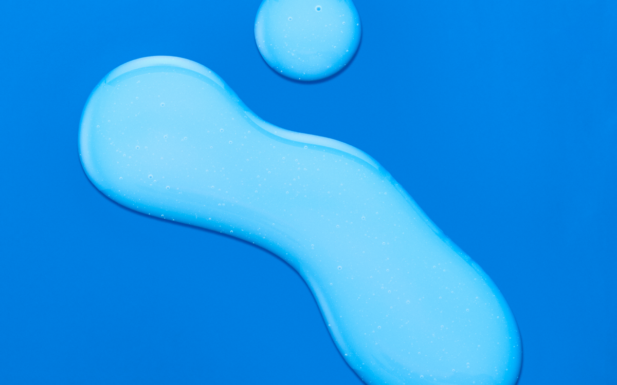 Swatch of blue serum on a bright blue background
